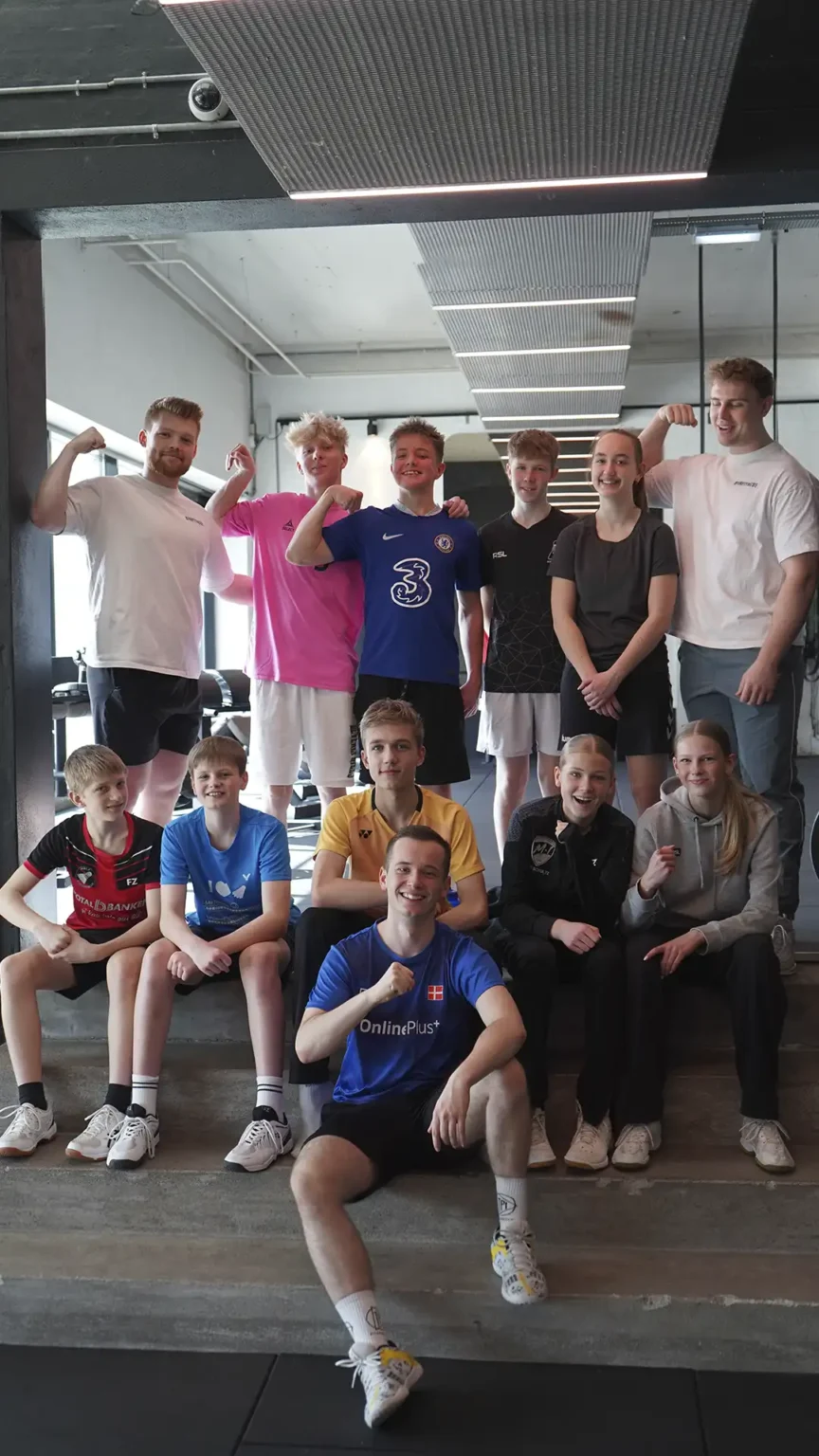 Elite badmintonhold modtager styrketræning med fokus på fysisk præstation.