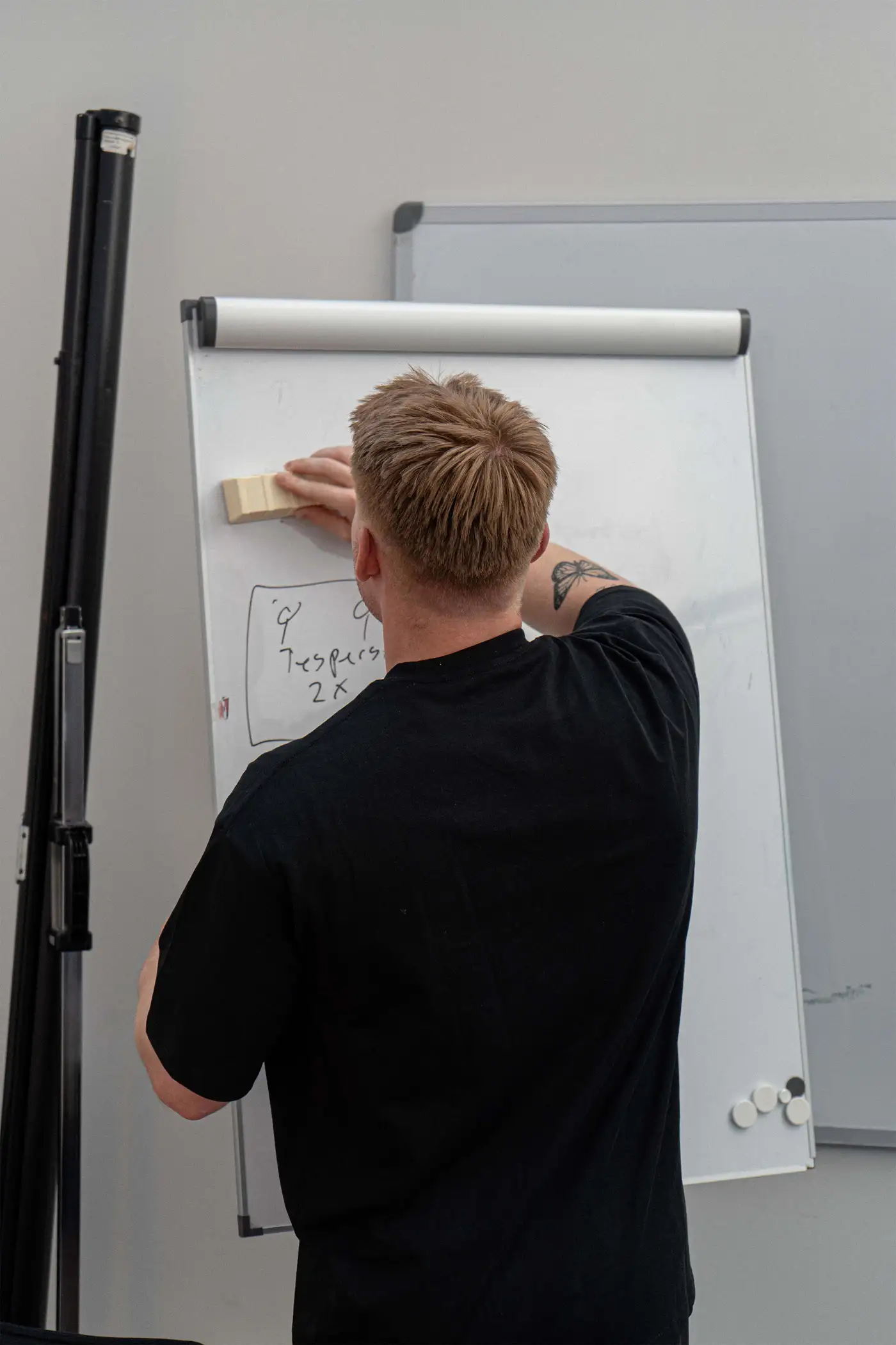 Træner skriver træningsprogram på whiteboard.